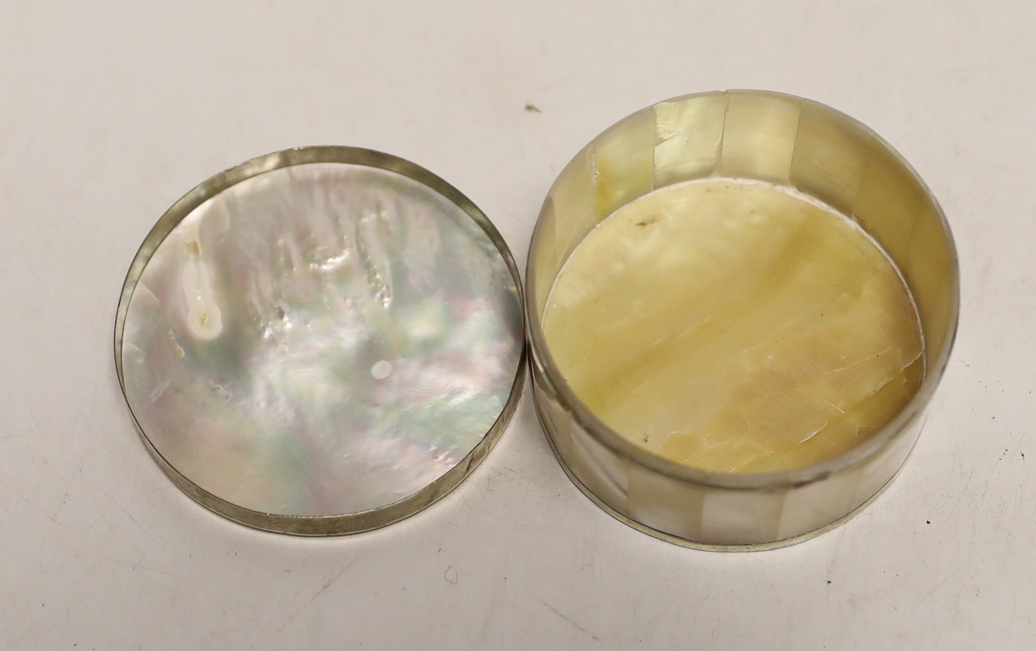 A white metal mounted mother of pearl circular box and cover, diameter 62mm.
